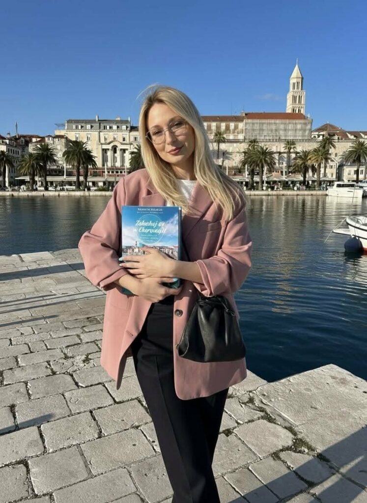 Agnieszka Grudziąż z książką „Zakochaj się w Chorwacji” na chorwackiej promenadzie