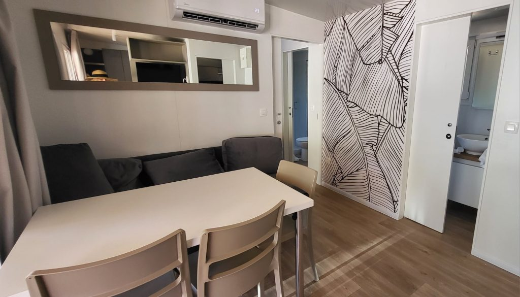 Salon z kanapą, stołem jadalnym i klimatyzacją w domku Glamping de Lux